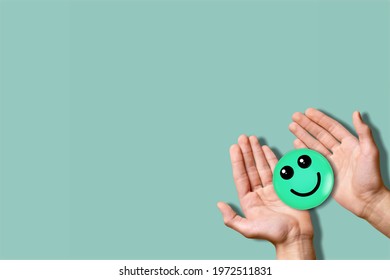 Hand holding paper cut smile face, world mental health day concept - Shutterstock ID 1972511831