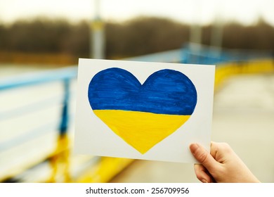 Hand Holding Paper Heart With Painted Ukraine Flag 