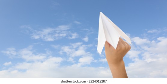 Hand Holding Paper Plane Against Blue Sky