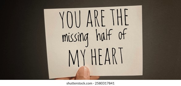 Hand Holding Paper with the Words 'You Are the Missing Half of My Heart' - Romantic Love Quote. 