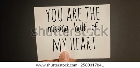 Hand Holding Paper with the Words 'You Are the Missing Half of My Heart' - Romantic Love Quote. 