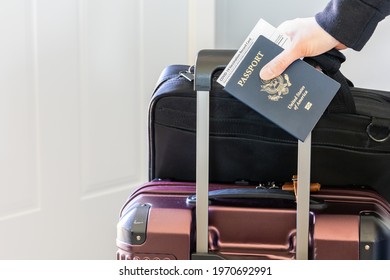 Hand Holding Passport And Covid Vaccination Card With Laptop Bag And Luggage Ready For Business Trip. Vaccine Document And Citizenship Identity Of Passenger, Traveler Require For International Travel.