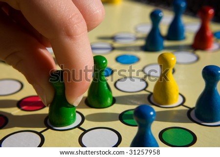 hand is holding pawns on play field