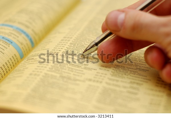 Hand holding a pen an a\
phone book