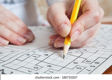 Hand Holding a Pen Playing Sudoku