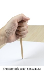 Hand Holding Pencil Stab On White Paper On Wooden Table