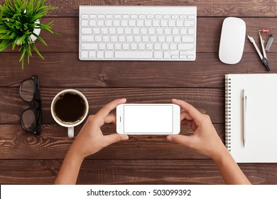 Hand Holding Phone Horizontal Showing Phone Blank Screen On Work Table, Mock Up Smartphone Rose Gold Color