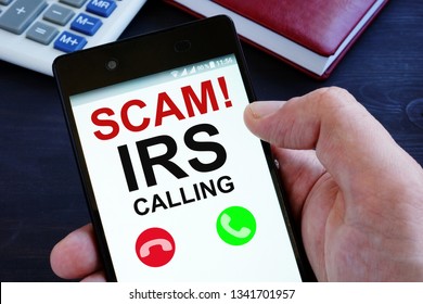 Hand Is Holding Phone With Irs Scam Calls.