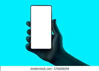 Hand holding phone. Silhouette of male hand holding smartphone isolated on aqua blue background. Bezel-less screen is cut with clipping path.