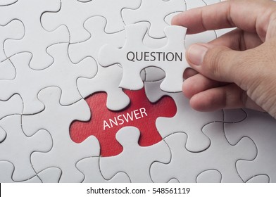 Hand holding piece of jigsaw puzzle with word question & answer. - Shutterstock ID 548561119