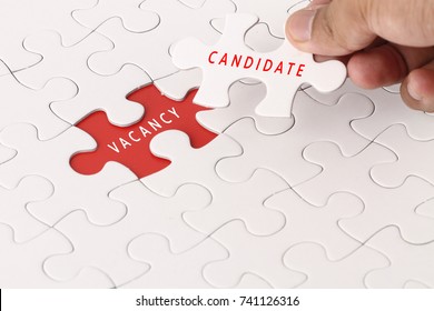 Hand holding piece of jigsaw puzzle with VACANCY and CANDIDATE wording - Shutterstock ID 741126316