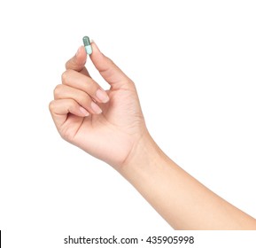 Hand holding a pill between thumb and forefinger isolated on white background