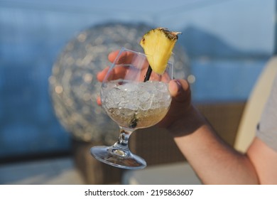 Hand Holding A Pina Colada Cocktail With Ice