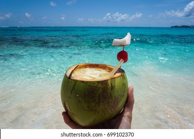 Woman´s Hand Holding A Pina Colada Drink Made In The Coconut On A Beach In The Caribbean Island Of San Andres, Colombia