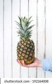 Hand holding pineapple 
