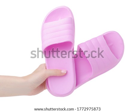 Hand holding pink female rubber slippers on white background isolation