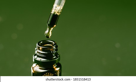 Hand holding pipette of cannabis oil. CBD As Alternative Medicine.