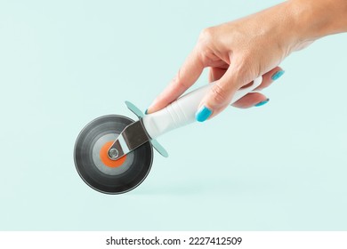 Woman’s hand holding pizza cutter with vinyl record on isolated pastel background. Minimal abstract creative retro musical concept of vintage music concert, festival or dj party. Invitation card. - Powered by Shutterstock