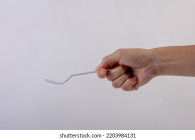 Hand Holding A Plastic Fork On White Background