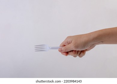 Hand Holding A Plastic Fork On White Background