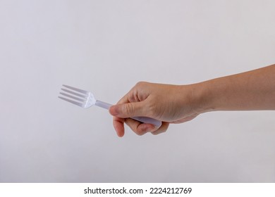 Hand Holding A Plastic Fork On White Background