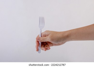 Hand Holding A Plastic Fork On White Background