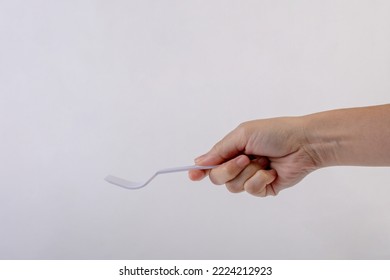 Hand Holding A Plastic Fork On White Background