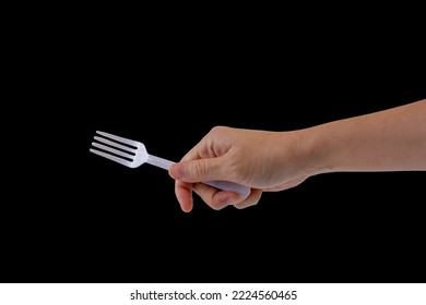 Hand Holding A Plastic Fork On Black Background