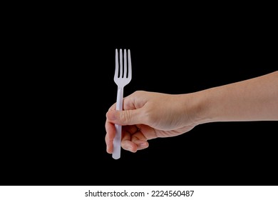 Hand Holding A Plastic Fork On Black Background