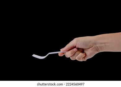 Hand Holding A Plastic Fork On Black Background