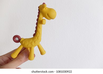 A Hand Holding A Plastic Giraffe Toy