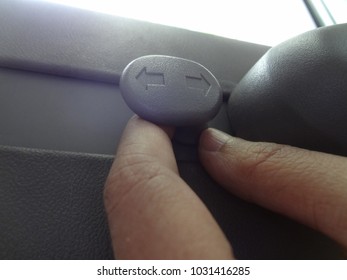 Hand Holding Plastic Hook Of Coat Hanger For Hanging Cloths In A Car.