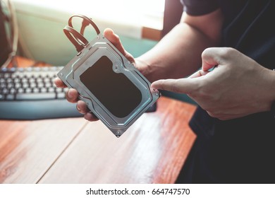Hand holding and  pointing at hard disk