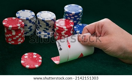Hand holding Poker cards Two Aces. Gambling, casino chips, dices. Casino tokens, gaming chips, checks, or cheques.