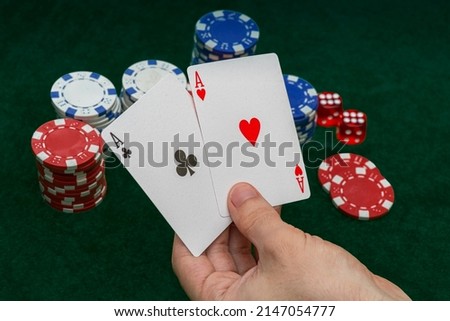 Hand holding Poker cards Two Aces. Gambling, casino chips, dices. Casino tokens, gaming chips, checks, or cheques.