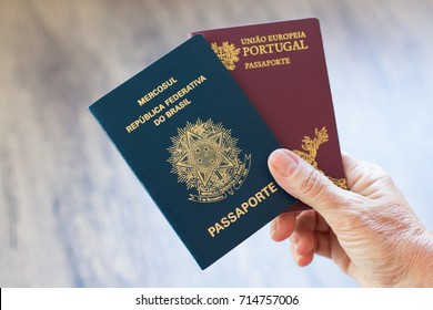 Hand holding Portuguese passport and Brazilian passport