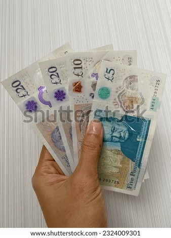 A hand holding Pound sterling money with white background