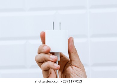 Hand holding preparing to connect USB type c adapter plug into electrical wall outlet, Electrical equipment, Connect the charger connector to household power. Energy saving concept.