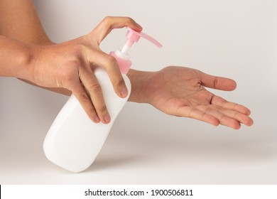 The Hand Was Holding The Pump Bottle And Pressing The Lotion Onto The Palm.