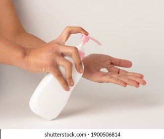 The Hand Was Holding The Pump Bottle And Pressing The Lotion Onto The Palm.