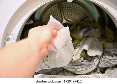 Hand Holding And Put Dryer Sheet Into A Tumble Clothes Dryer.