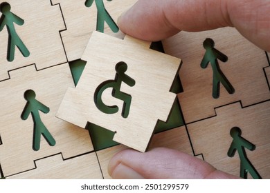 Hand holding puzzle piece with disability symbol. Concept of inclusion in work and society.