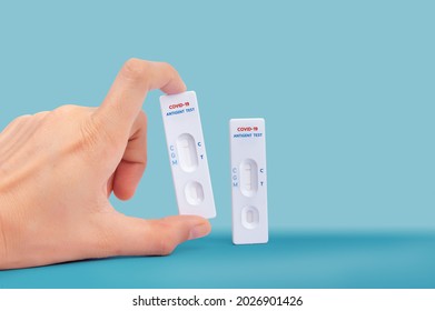 Hand holding Quick antibody detection test Coronavirus detection one step test kit. showing positive and negative result Fast COVID-19 serologic diagnostic test Self  antigen rapid test concept  - Shutterstock ID 2026901426