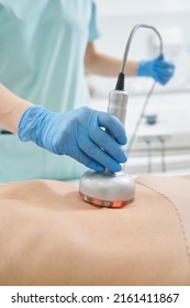 Hand Holding Radiofrequency Beauty Gadget On Stomach