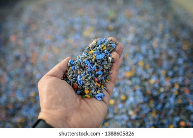 Hand Holding Recycled Plastic Chips As Raw Material In Production.