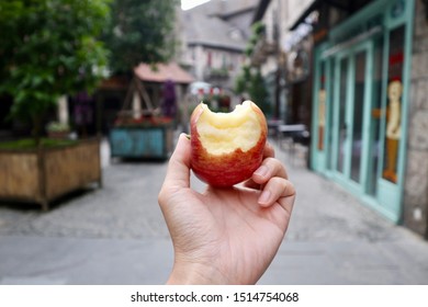 Hand Holding Red Apple With Missing A Bite