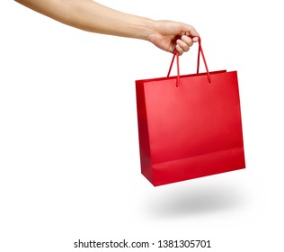 Hand holding a red color shopping bag isolated on white