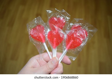 Hand Holding Red Heart Shaped Lollies Candy Bars Wrapped Give Away Sweets Love On Stick For Valentines Day Family Friends Romantic Relationship Date 14 February Holiday