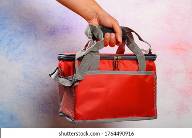 Hand Holding A Red Lunch Pack Carrier Or Insulation Bag