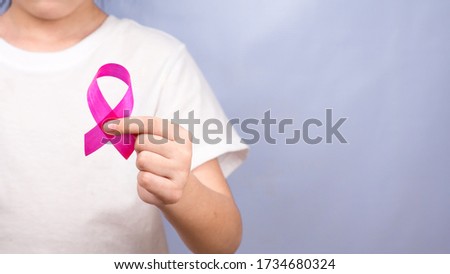 Hand holding red pink ribbon background.
October breast cancer awareness month.
Women day and World cancer day concept.
top view.  